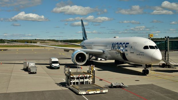 Norse Atlantic Airways Boeing 787-9 parked at a gate at Oslo Airport with ground equipment nearby