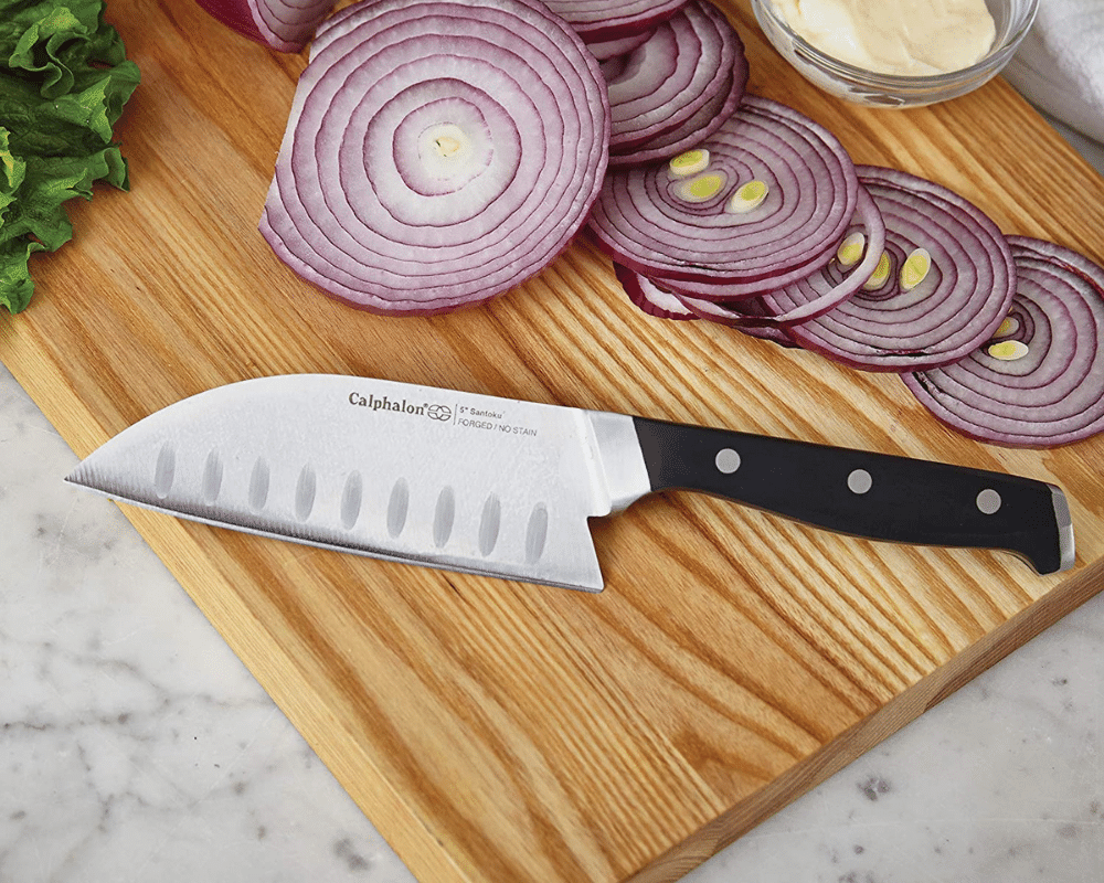 A self-sharpening knife on cutting board with purple onions and lettuce