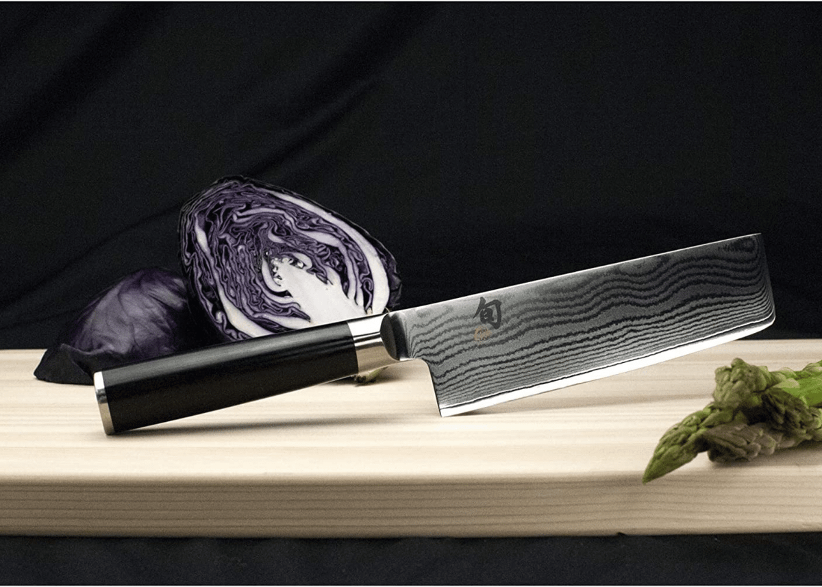 A Damascus Nakiri with cut vegetables on a cutting board
