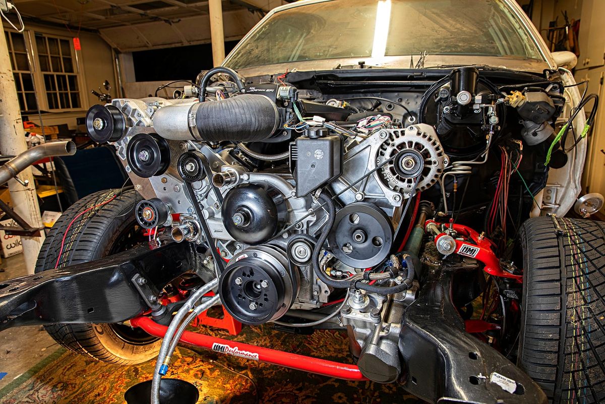 A GM G body with a LS engine being installed with the front clip removed.