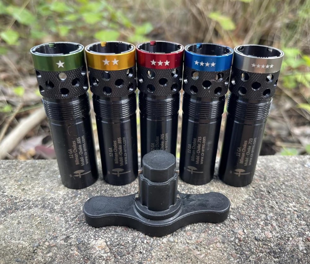 A ported choke set with wrench sitting on a large stone, each 12ga choke is color coded for identification