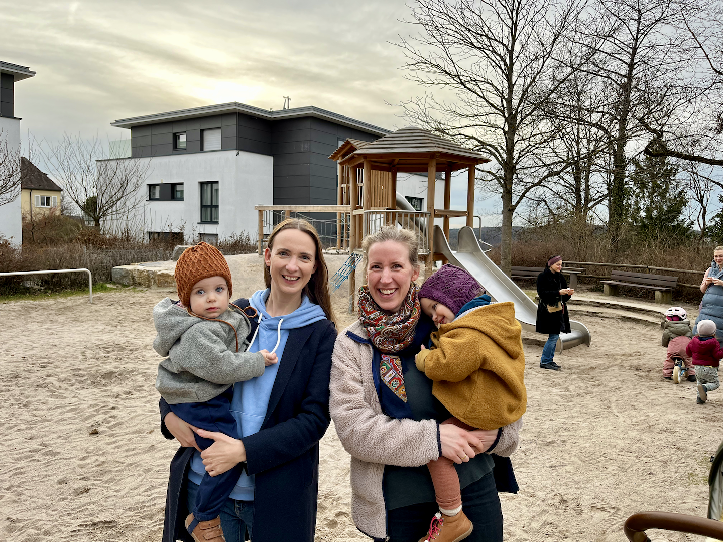 Two mums and their children on a playground