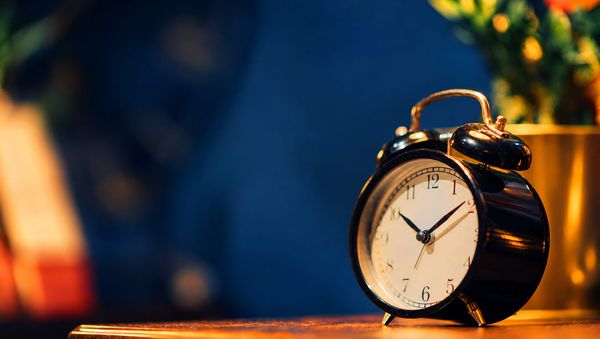 A classic twin-bell alarm clock in soft light