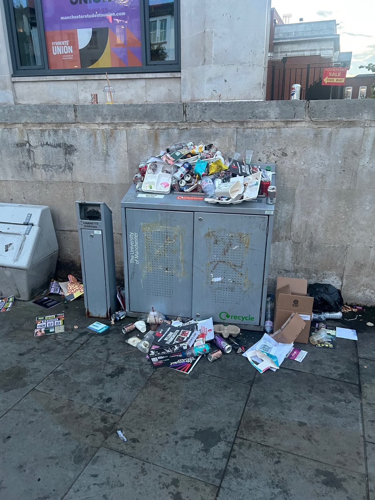 A litter bin overflowing with all sorts of litter.