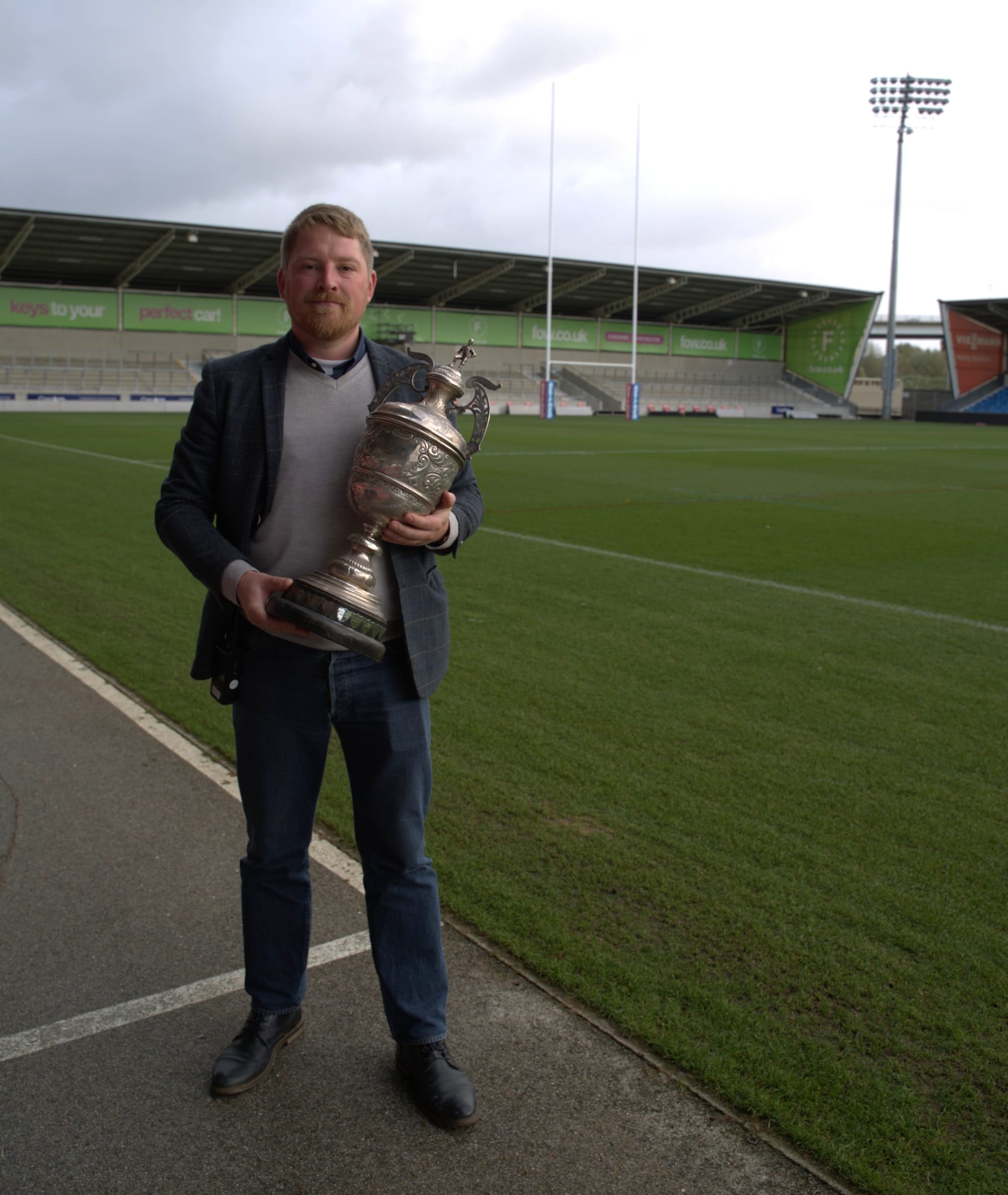 Jack Youd holding the Valentine cup in the Salford Red Devils stadium.
