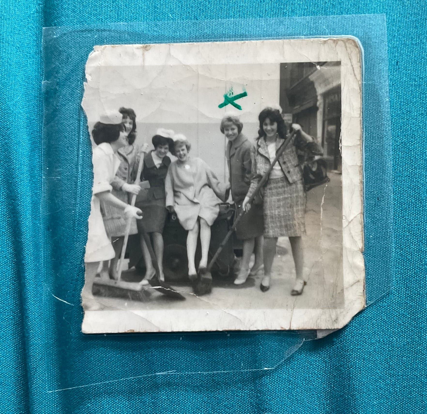 Sue Hall and five friends in the early 1960s, smiling at the camera and holding big brushes