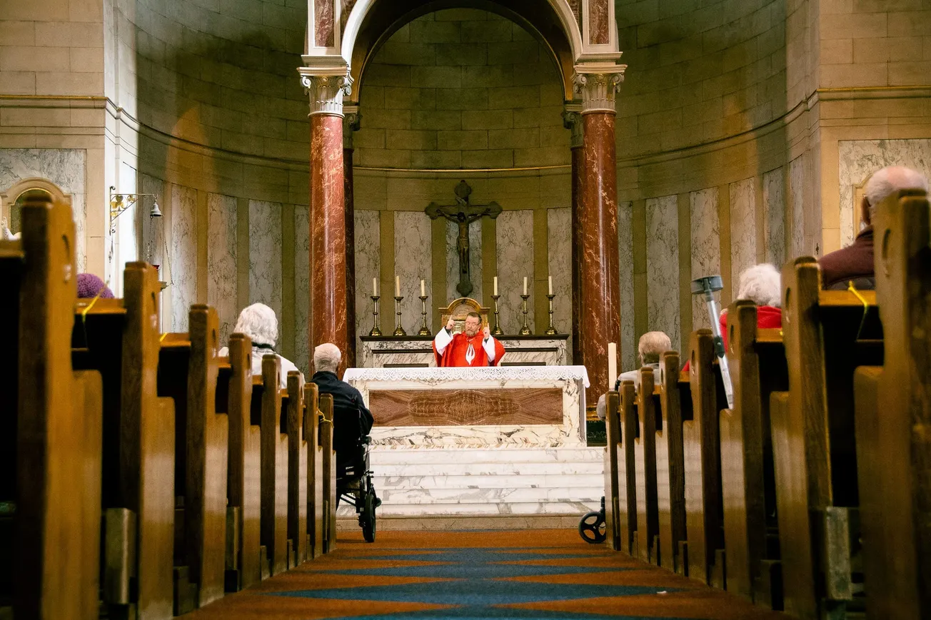 A priest welcomes back his flock for the start of Holy Week