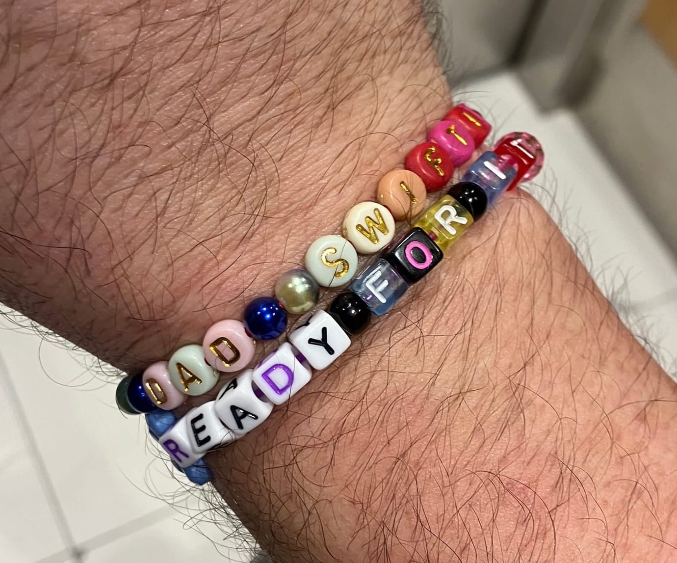 My hairy forearm with "Dad Swiftie" and "Ready For It" friendship bracelets on it. At the Eras Tour Toronto N1, 11/14/24.