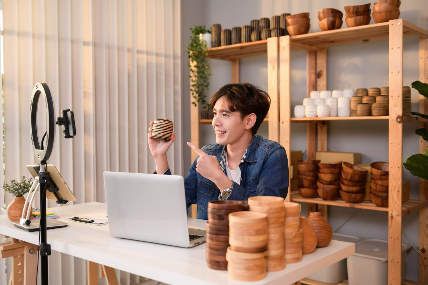 A young Asian man entrepreneur live streaming to sale craft products to customers