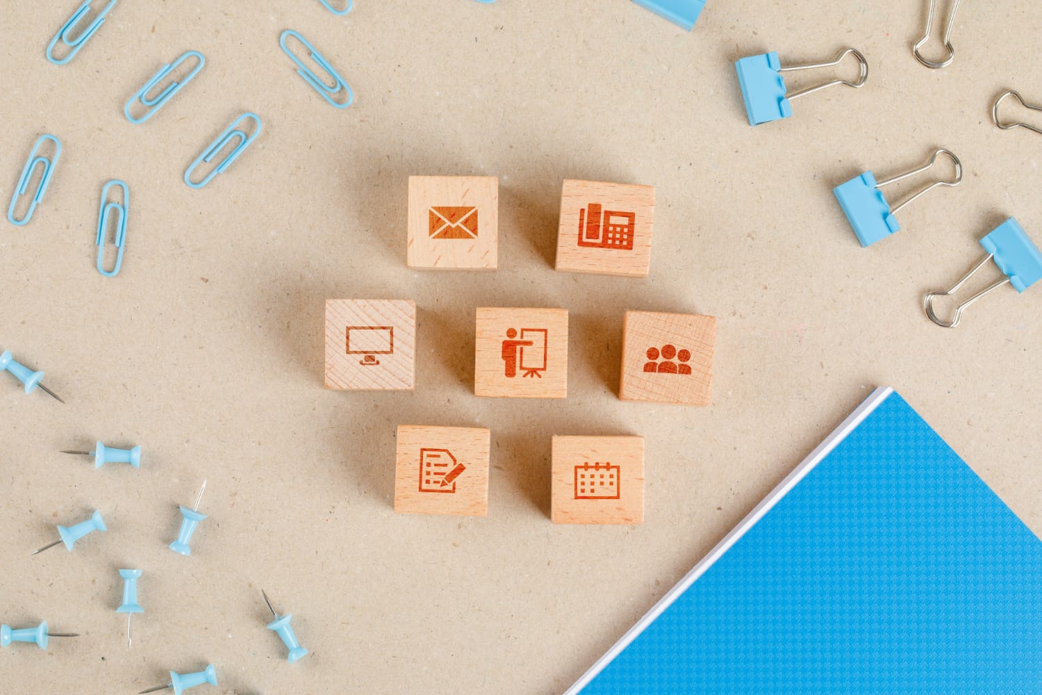 Office supplies concept with icons on wooden cubes, stationery set flat lay.
