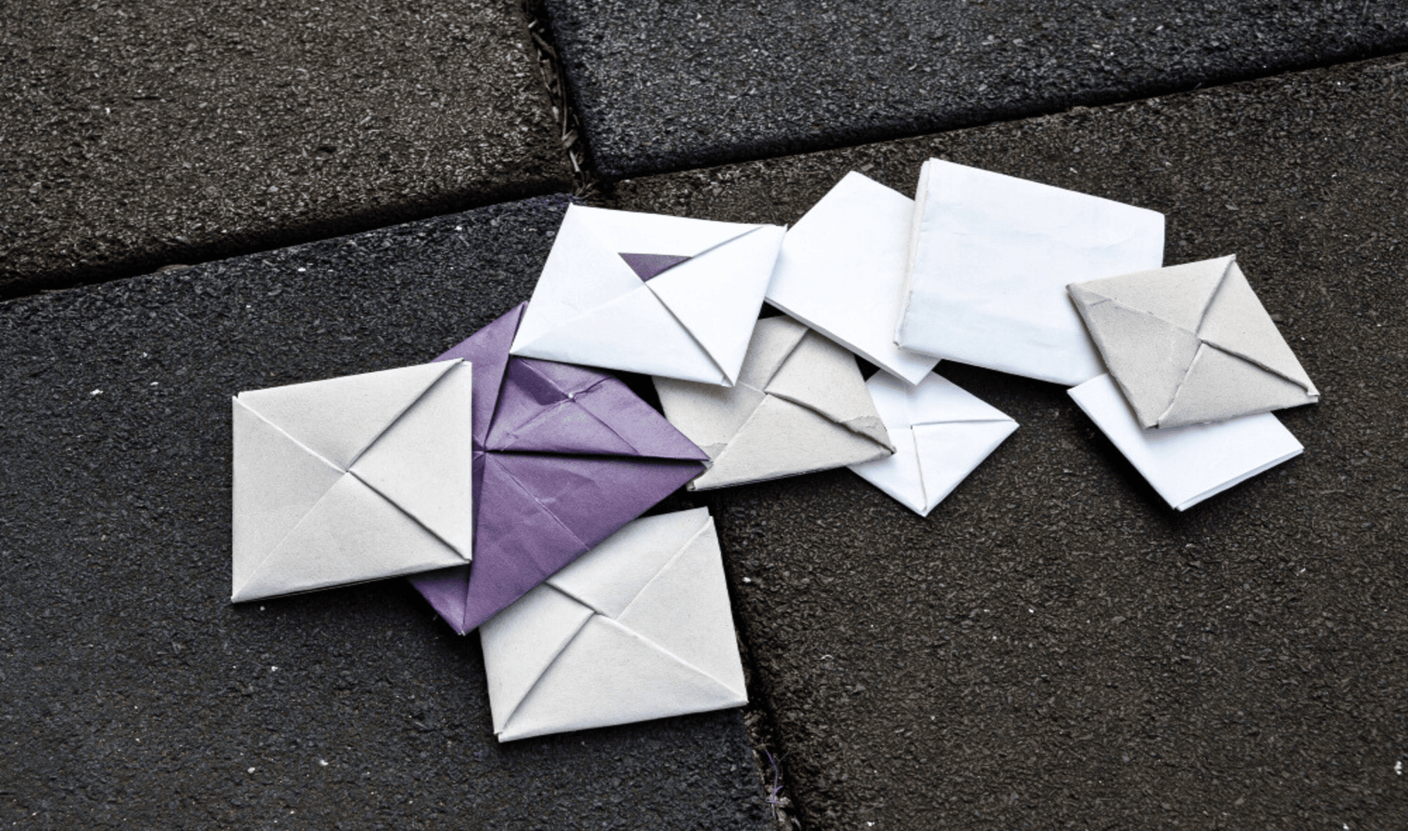 Undelivered mails are scattered on the grey road. 