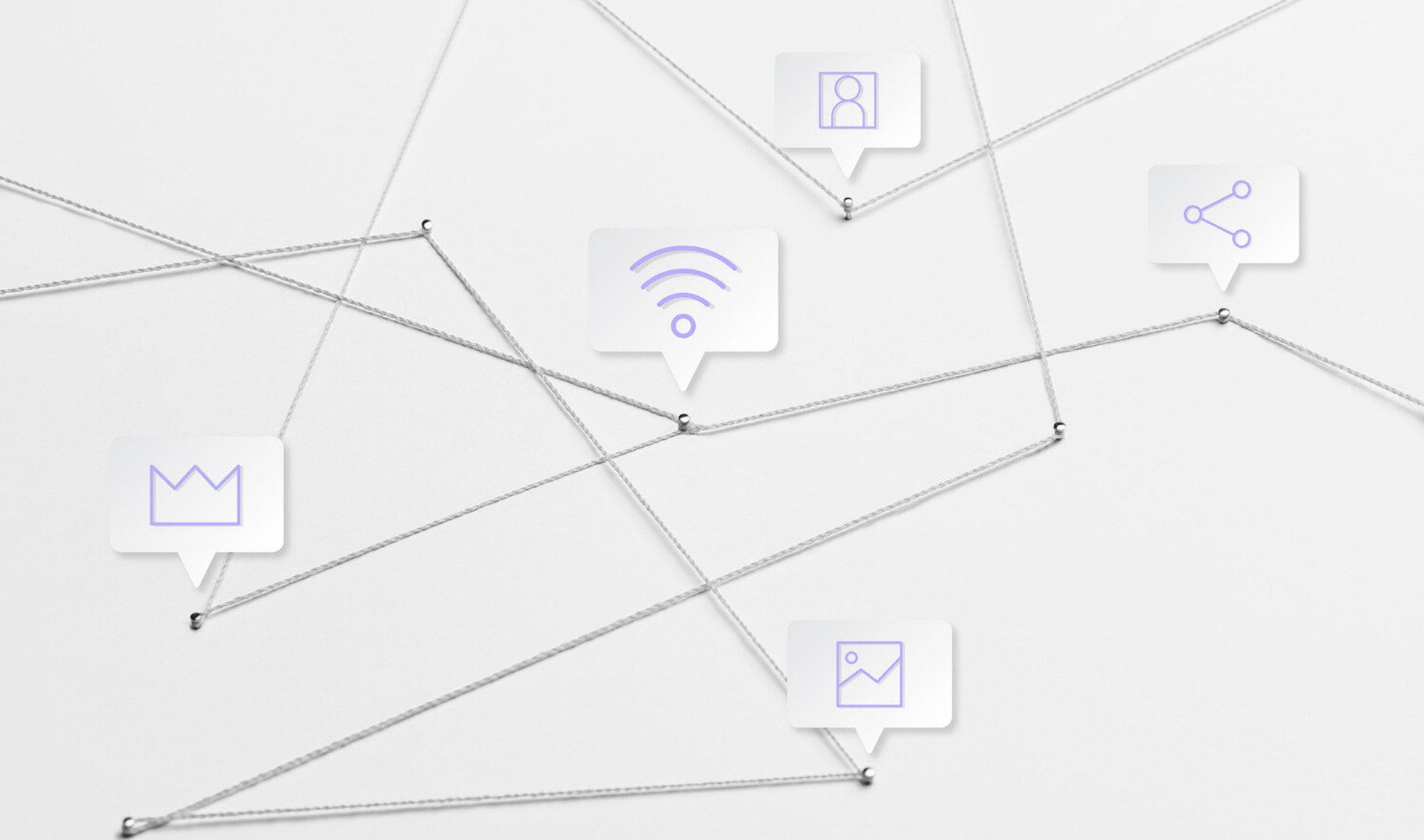 Various symbols of marketing are pinned with threads on a piece of white paper.