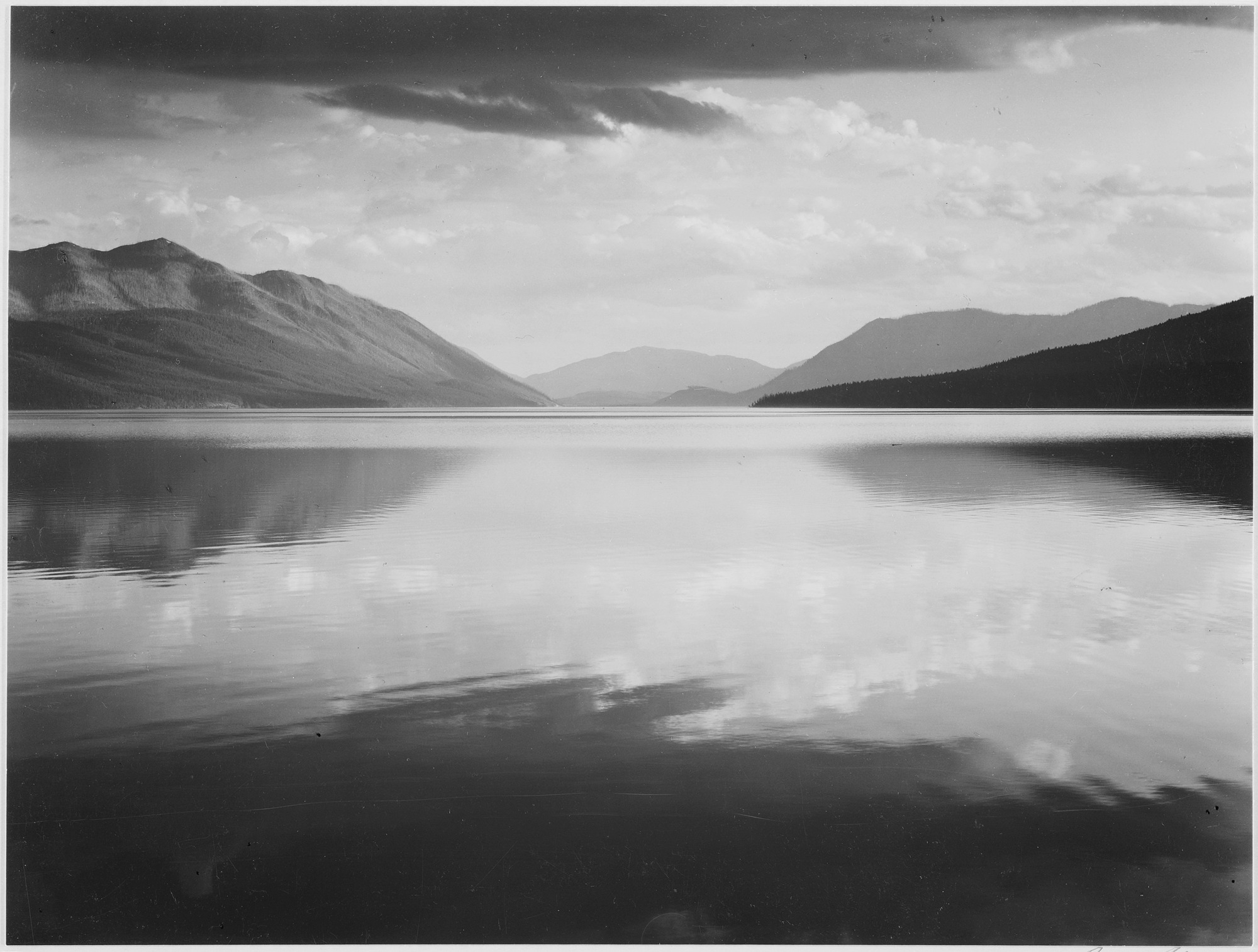 "Looking across lake toward mountains, "Evening, McDonald Lake, Glacier National Park," Montana., 1933 - 1942 - NARA - 519861" by Ansel Adams - U.S. National Archives and Records Administration. 