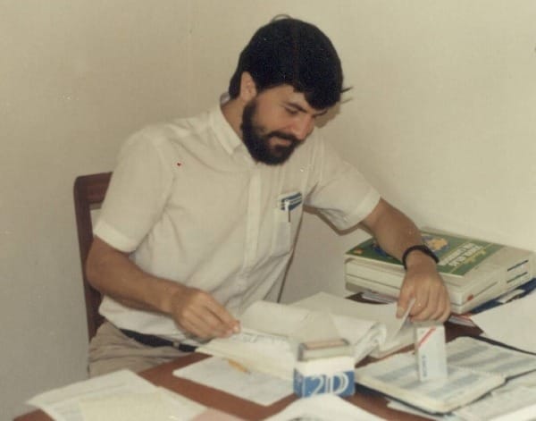 A young man working at a desk by a window