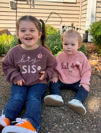 Two small girls sitting side-by-side