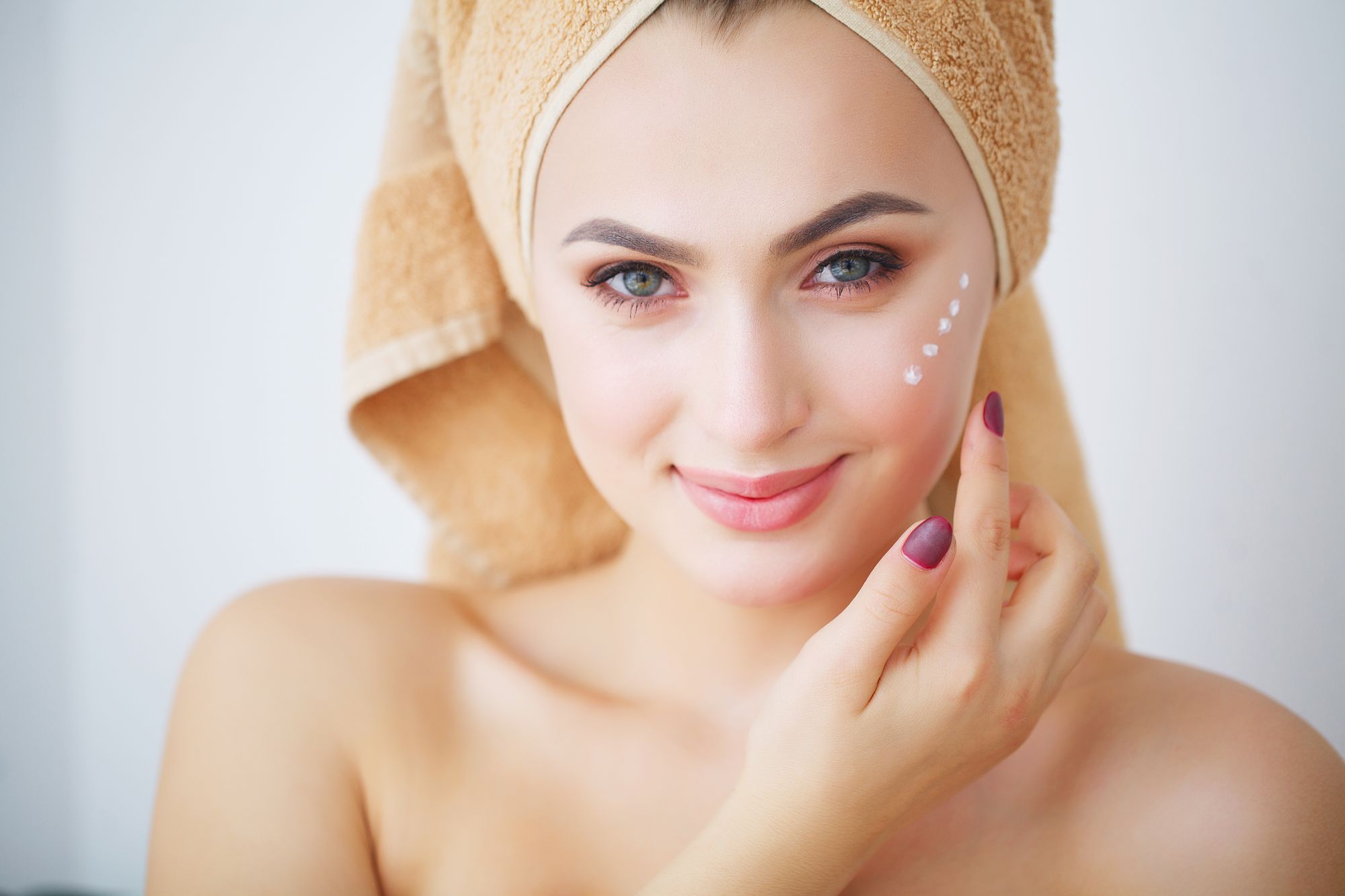 woman with dots of eye cream around her eye
