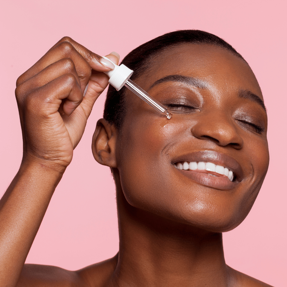 woman with eyes closed holding a dropper to her cheek