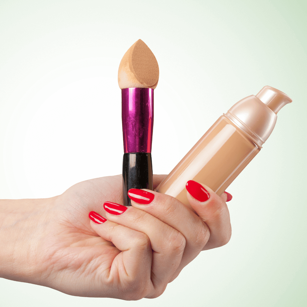 closeup picture of woamn's hand holding tinted moisturizer and sponge applicator