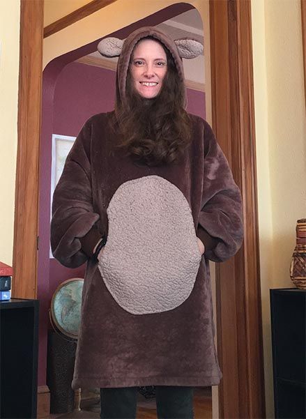 Me, standing, wearing a snuggly bear outfit, with my hands tucked into a tummy pouch on the front.