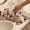  A woman's hand reaching toward a crowded collection of skincare products on a bathroom counter.