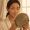  Woman looking closely at her skin in a mirror
