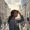  Woman with deep brown skin shielding her face from sunlight in a hazy city environment