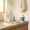 Simple skincare routine on bathroom counter beside water and supplement bottle
