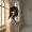 Sunlight falling across one side of a woman's face near a window.