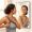 Woman adjusting a bra strap while looking at her shoulder in a mirror