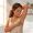 Woman examining her underarm skin while holding a razor