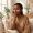 Woman gently touching her cheek in a calm setting during skin recovery