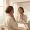 Woman gently touching her neck while observing subtle pigmentation changes in the mirror