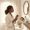 Woman going through a calm morning skincare routine in a bright bathroom