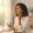 Woman holding sunscreen while sunlight comes through a window