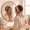 Woman looking at her face in the mirror with an expression of uncertain patience.