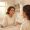 Woman studying her skin in bathroom mirror with thoughtful expression