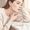 Woman touching her jawline with a skincare product nearby