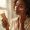 Woman with deep brown skin applying sunscreen in morning light