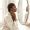 Woman with deep brown skin examining pigmentation along her jawline