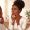 Woman with deep brown skin gently assessing a faint area of irritation along her jawline