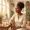 Woman with deep brown skin in soft morning light with water and supplement capsules on the table beside her