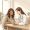 Woman with medium-brown skin in a relaxed conversation with a doctor in a clinical setting