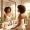 Woman with medium-brown skin looking calmly at her reflection in morning light