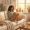 Woman with medium-deep skin sitting with tea in warm afternoon light, relaxed and thoughtful