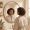 Woman with medium-deep skin tone looking at subtle melasma in her bathroom mirror with a calm expression.