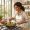 Woman with warm brown skin preparing a colourful meal in a bright kitchen
