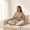 Woman with warm brown skin sitting on a sofa with her hand resting on her stomach