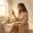 Woman reading a serum label while sitting on a bathtub edge