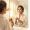 Woman with a serum bottle looking in the mirror