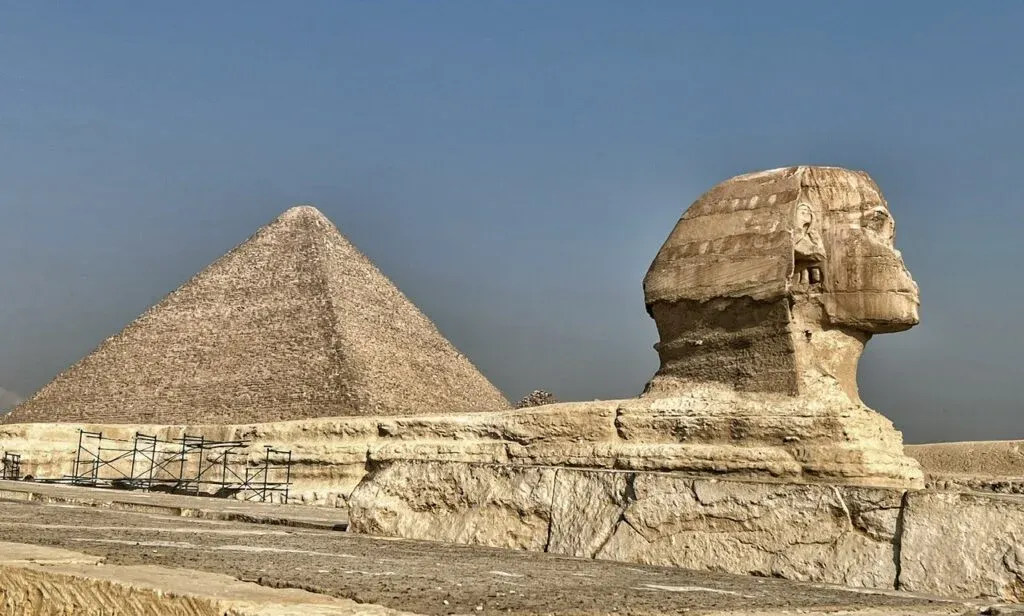 The Great Sphinx of Giza with a pyramid looming behind